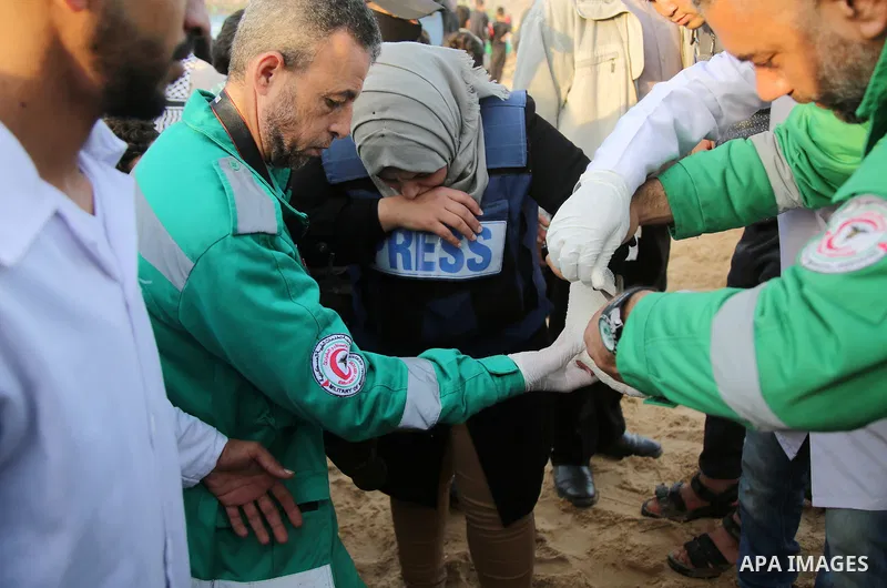Palestinian medics help a Palestinian female journalist who was wounded during clashes with Israeli forces in a demonstration against the Israeli blockade on Gaza Strip, along the Gaza sea barrier on the maritime border...