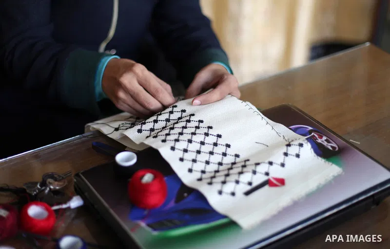 A disabled Palestinian woman Heda Abu Ouda, 38, works on a handmade embroidered products to sell its for customers at her workshop in Gaza City on November 27, 2018. Photo by Mahmoud Ajjour