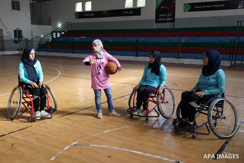 A disabled Palestinian woman on a wheelchair Heda Abu Ouda, 38, takes part in a basketball lesson, at a club in Gaza City on November 27, 2018. Photo by Mahmoud Ajjour