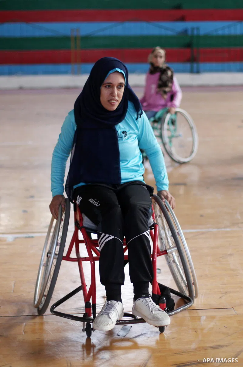 A disabled Palestinian woman on a wheelchair Heda Abu Ouda, 38, takes part in a basketball lesson, at a club in Gaza City on November 27, 2018. Photo by Mahmoud Ajjour
