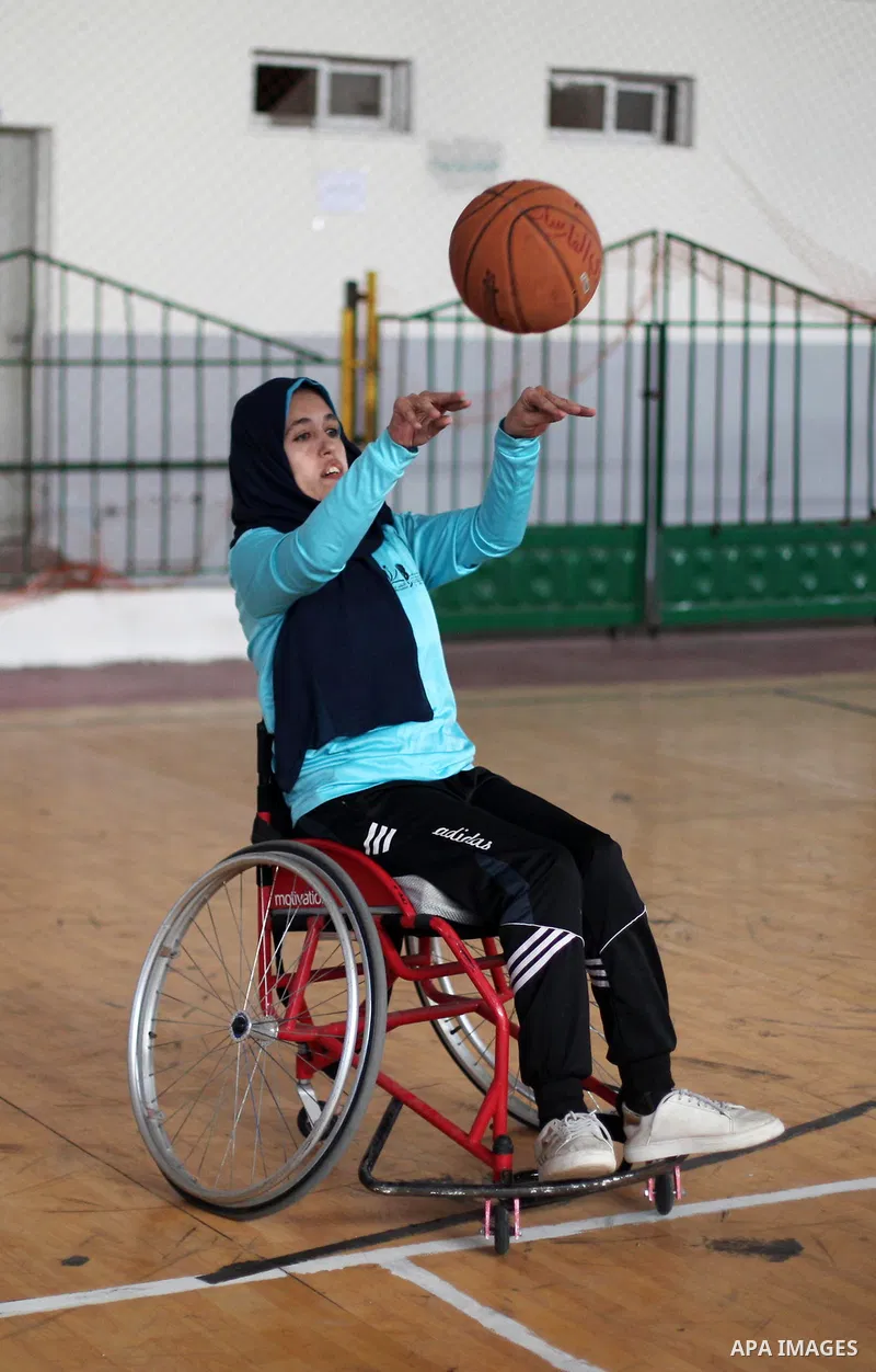 A disabled Palestinian woman on a wheelchair Heda Abu Ouda, 38, takes part in a basketball lesson, at a club in Gaza City on November 27, 2018. Photo by Mahmoud Ajjour