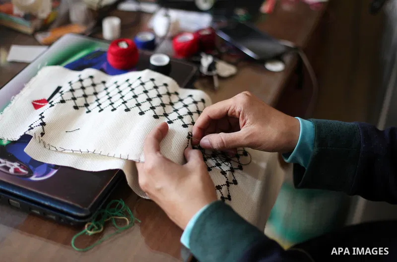 A disabled Palestinian woman Heda Abu Ouda, 38, works on a handmade embroidered products to sell its for customers at her workshop in Gaza City on November 27, 2018. Photo by Mahmoud Ajjour