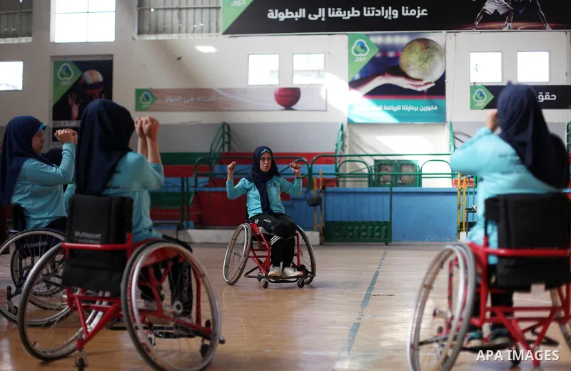 A disabled Palestinian woman on a wheelchair Heda Abu Ouda, 38, takes part in a basketball lesson, at a club in Gaza City on November 27, 2018. Photo by Mahmoud Ajjour