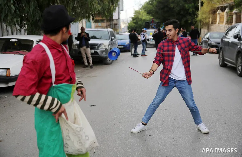 A Palestinian youth performs with YoYo game at street during a street carnival in the West Bank city of Nablus on November 28, 2018. Photo by Shadi Jarar'ah