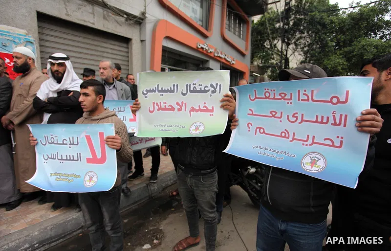 Palestinian supporters of the Islamic Jihad Movement hold placards during a protest against the political arrests in the West Bank, in Gaza city, on November 29, 2018. Photo by Mahmoud Ajjour