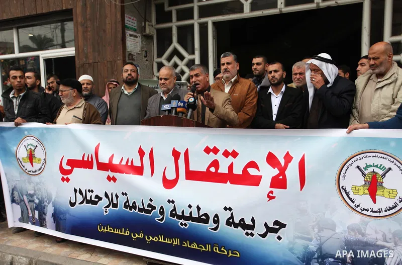 Palestinian supporters of the Islamic Jihad Movement hold placards during a protest against the political arrests in the West Bank, in Gaza city, on November 29, 2018. Photo by Mahmoud Ajjour