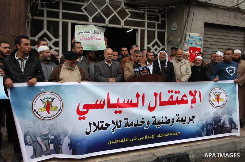 Palestinian supporters of the Islamic Jihad Movement hold placards during a protest against the political arrests in the West Bank, in Gaza city, on November 29, 2018. Photo by Mahmoud Ajjour