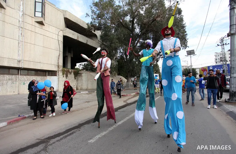 Palestinian clowns perform at street during a street carnival in Gaza city, on November 29, 2018. Photo by Mahmoud Ajjour