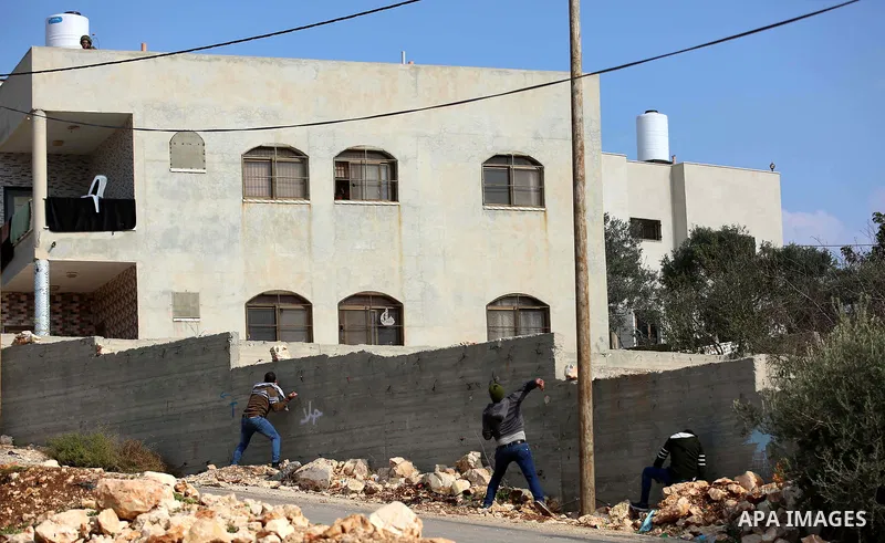 Palestinian protesters hurl stones towards Israeli forces during clashes following a weekly demonstration against the expropriation of Palestinian land by Israel in the village of Kfar Qaddum, near the West Bank city of...