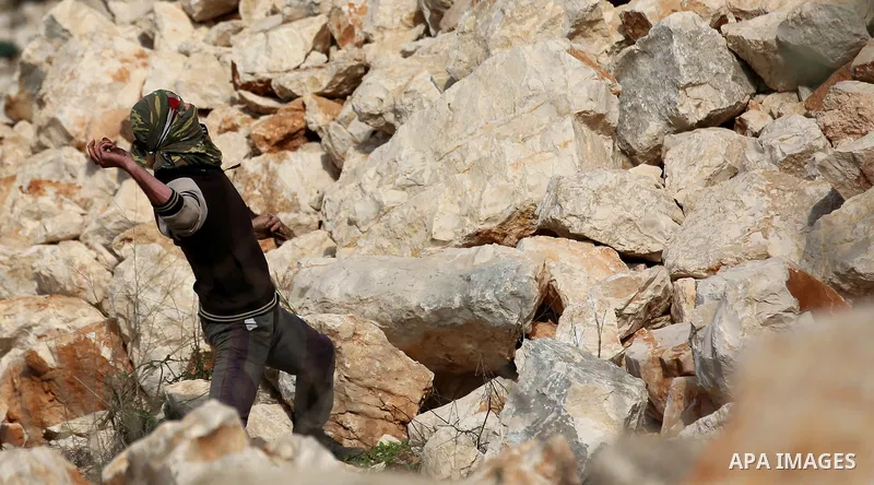 Palestinian protesters hurl stones towards Israeli forces during clashes following a weekly demonstration against the expropriation of Palestinian land by Israel in the village of Kfar Qaddum, near the West Bank city of...
