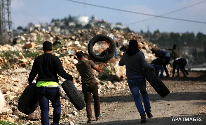 Palestinian protesters burn tires during clashes with Israeli forces during clashes following a weekly demonstration against the expropriation of Palestinian land by Israel in the village of Kfar Qaddum, near the West Ba...
