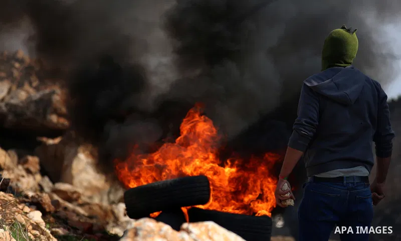Palestinian protesters burn tires during clashes with Israeli forces during clashes following a weekly demonstration against the expropriation of Palestinian land by Israel in the village of Kfar Qaddum, near the West Ba...