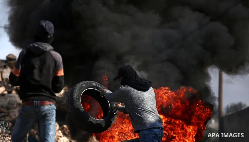 Palestinian protesters burn tires during clashes with Israeli forces during clashes following a weekly demonstration against the expropriation of Palestinian land by Israel in the village of Kfar Qaddum, near the West Ba...