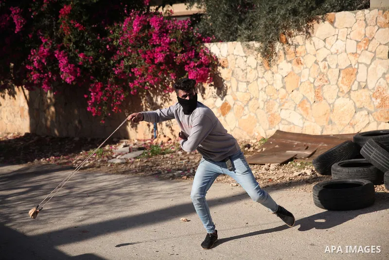 Palestinian protesters hurl stones towards Israeli forces during clashes following a weekly demonstration against the expropriation of Palestinian land by Israel in the village of Kfar Qaddum, near the West Bank city of...