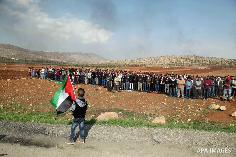 Palestinian protesters attend Friday prayers during clashes Israeli forces against Israeli land seizures for Jewish settlements, in the village of al-Mughayyir, near the West Bank city of Ramallah, on November 30, 2018....