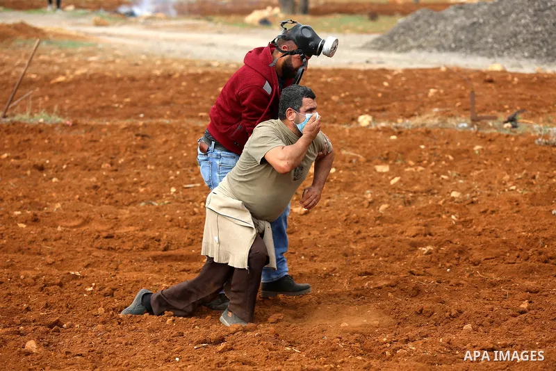 A Palestinian protester reacts from tear gas during clashes Israeli forces against Israeli land seizures for Jewish settlements, in the village of al-Mughayyir, near the West Bank city of Ramallah, on November 30, 2018....