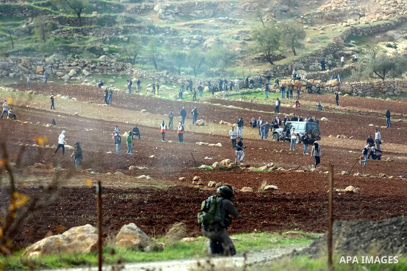 Palestinian protesters hurl stones towards Israeli forces during clashes against Israeli land seizures for Jewish settlements, in the village of al-Mughayyir, near the West Bank city of Ramallah, on November 30, 2018. Ph...