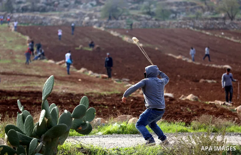 Palestinian protesters hurl stones towards Israeli forces during clashes against Israeli land seizures for Jewish settlements, in the village of al-Mughayyir, near the West Bank city of Ramallah, on November 30, 2018. Ph...