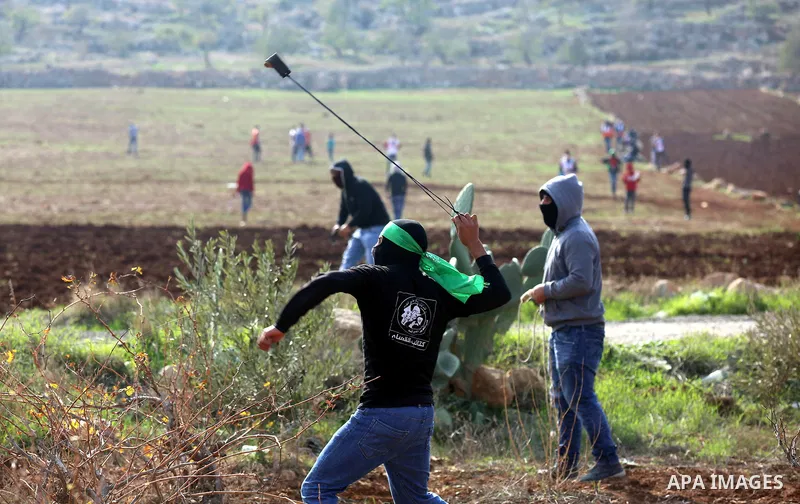 Palestinian protesters hurl stones towards Israeli forces during clashes against Israeli land seizures for Jewish settlements, in the village of al-Mughayyir, near the West Bank city of Ramallah, on November 30, 2018. Ph...