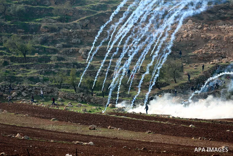 Tear gas canisters are fired by Israeli forces towards Palestinian protesters during a protest against Israeli land seizures for Jewish settlements, in the village of al-Mughayyir, near the West Bank city of Ramallah, on...