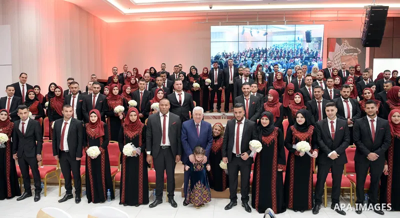 Palestinian President Mahmoud Abbas takes part in mass wedding celebration, in the West Bank city of Ramallah on November 29, 2018. Photo by Thaer Ganaim