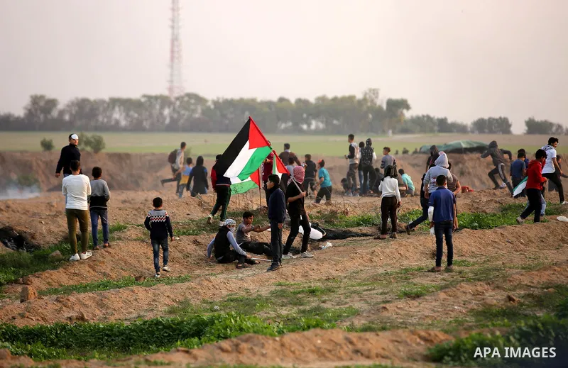 Palestinian protesters gather during clashes with Israeli troops in tents protest where Palestinians demand the right to return to their homeland at the Israel-Gaza border, in east of Gaza City on November 30, 2018. Phot...