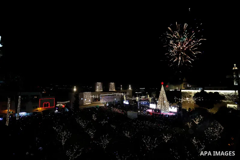Palestinian Christians watch as fireworks light the sky to mark the lighting of a Christmas tree on December 1, 2018 at the Manger Square near the Church of the Nativity, revered as the site of Jesus Christ's birth, in t...