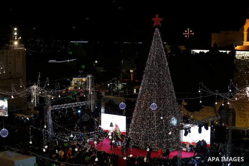Palestinian Christians watch as fireworks light the sky to mark the lighting of a Christmas tree on December 1, 2018 at the Manger Square near the Church of the Nativity, revered as the site of Jesus Christ's birth, in t...