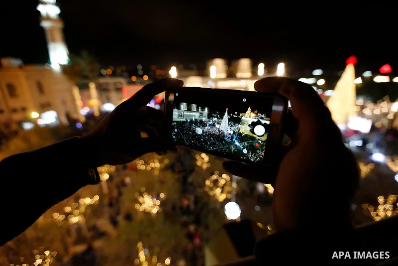 Palestinian Christians watch as fireworks light the sky to mark the lighting of a Christmas tree on December 1, 2018 at the Manger Square near the Church of the Nativity, revered as the site of Jesus Christ's birth, in t...