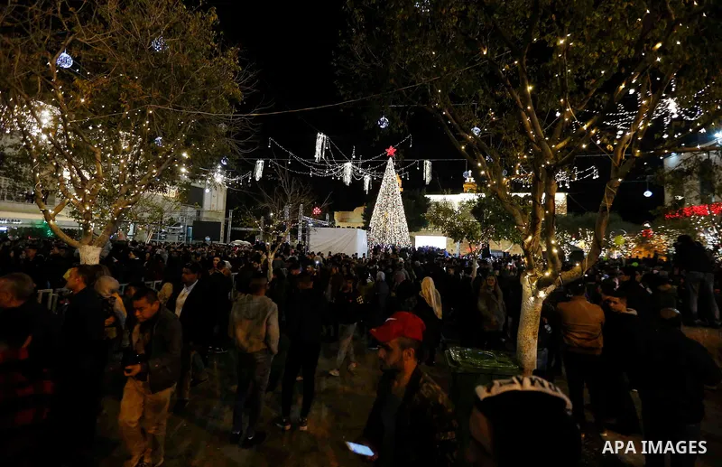 Palestinian Christians watch as fireworks light the sky to mark the lighting of a Christmas tree on December 1, 2018 at the Manger Square near the Church of the Nativity, revered as the site of Jesus Christ's birth, in t...