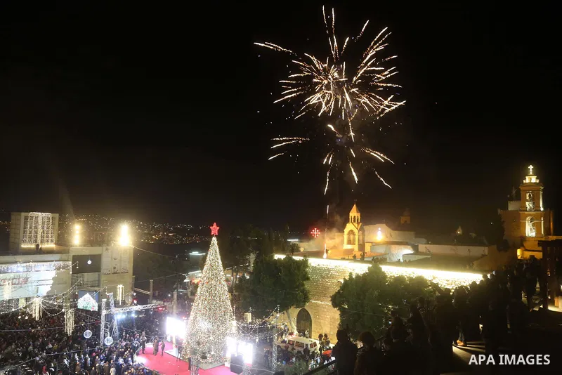 Palestinian Christians watch as fireworks light the sky to mark the lighting of a Christmas tree on December 1, 2018 at the Manger Square near the Church of the Nativity, revered as the site of Jesus Christ's birth, in t...