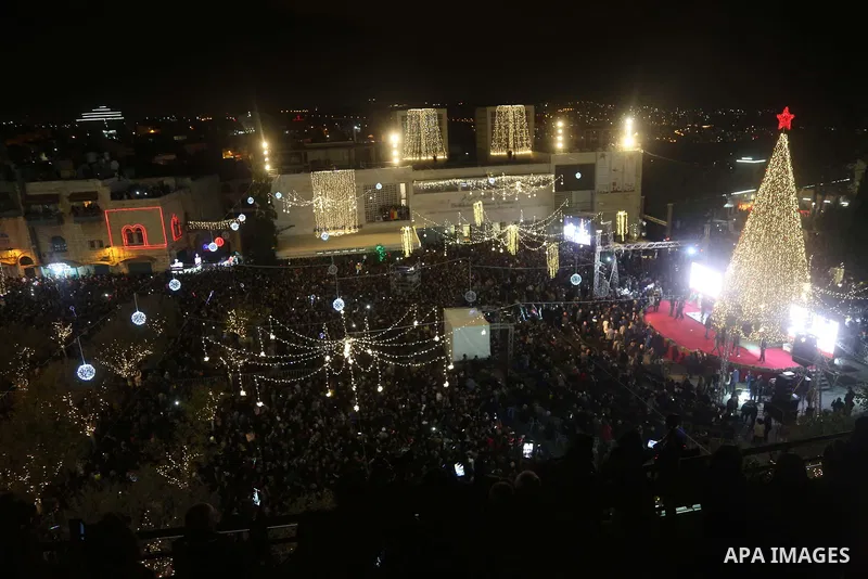 Palestinian Christians watch as fireworks light the sky to mark the lighting of a Christmas tree on December 1, 2018 at the Manger Square near the Church of the Nativity, revered as the site of Jesus Christ's birth, in t...