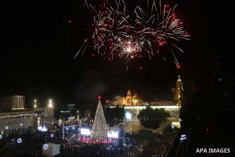 Palestinian Christians watch as fireworks light the sky to mark the lighting of a Christmas tree on December 1, 2018 at the Manger Square near the Church of the Nativity, revered as the site of Jesus Christ's birth, in t...