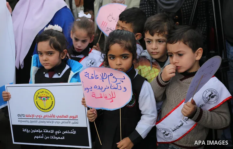 Palestinians and physically challenged people take part in a rally marking the International Day of Persons with Disabilities, in Gaza City, on December 2, 2018. Photo by Ashraf Amra