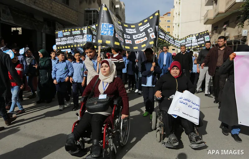 Palestinians and physically challenged people take part in a rally marking the International Day of Persons with Disabilities, in Gaza City, on December 2, 2018. Photo by Ashraf Amra