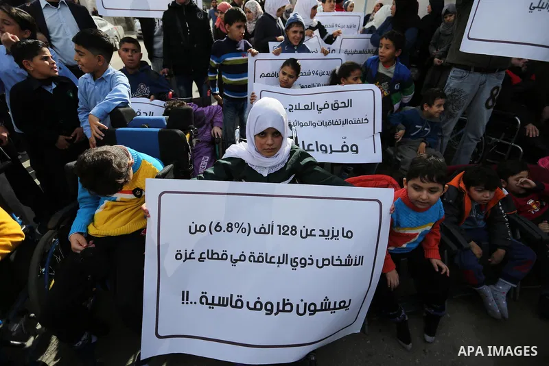 Palestinians and physically challenged people take part in a rally marking the International Day of Persons with Disabilities, in Gaza City, on December 2, 2018. Photo by Ashraf Amra