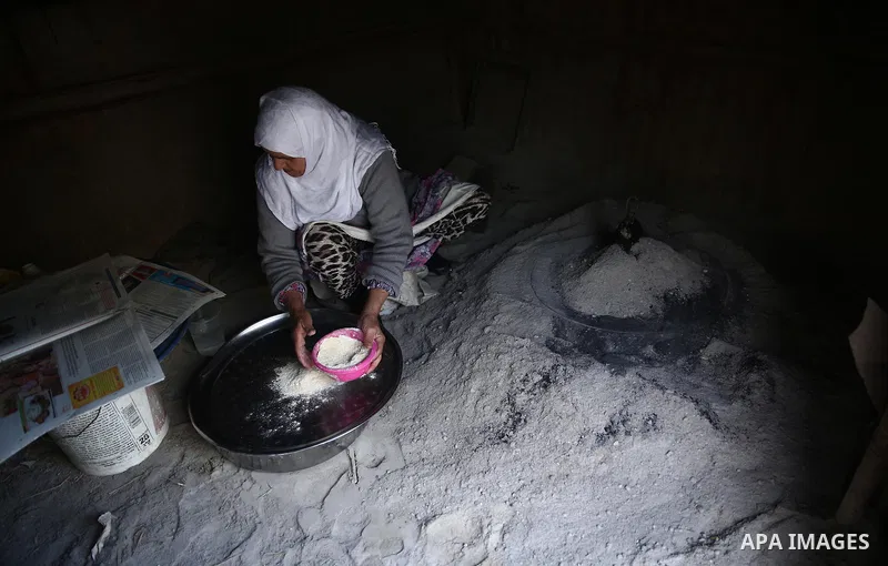 A Palestinian woman bakes traditional bread "Taboon" in the village of Salem east the West Bank City of Nablus, on December, 3, 2018. Photo by Shadi Jarar'ah