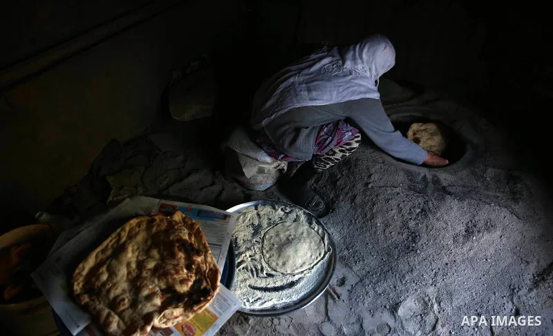 A Palestinian woman bakes traditional bread "Taboon" in the village of Salem east the West Bank City of Nablus, on December, 3, 2018. Photo by Shadi Jarar'ah