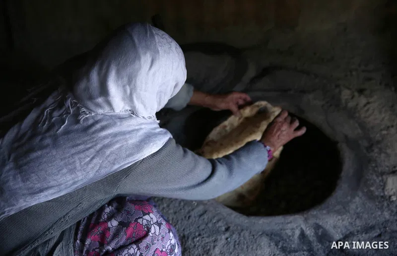 A Palestinian woman bakes traditional bread "Taboon" in the village of Salem east the West Bank City of Nablus, on December, 3, 2018. Photo by Shadi Jarar'ah