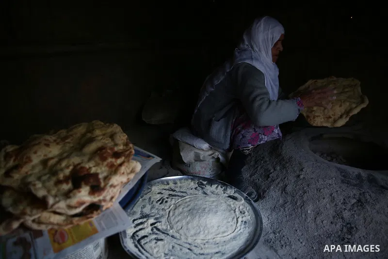 A Palestinian woman bakes traditional bread "Taboon" in the village of Salem east the West Bank City of Nablus, on December, 3, 2018. Photo by Shadi Jarar'ah