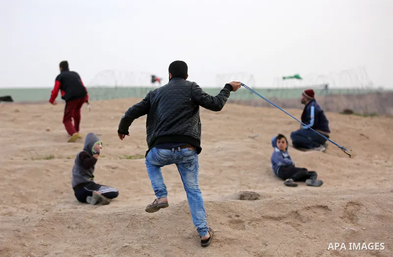Palestinian protesters gather during clashes with Israeli troops in tents protest where Palestinians demand the right to return to their homeland at the Israel-Gaza border, in east of Gaza City on December 7, 2018. Photo...