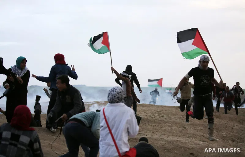 Palestinian protesters gather during clashes with Israeli troops in tents protest where Palestinians demand the right to return to their homeland at the Israel-Gaza border, in east of Gaza City on December 7, 2018. Photo...