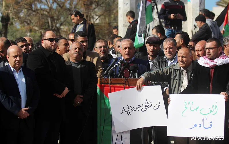 Palestinian members of National and Islamic forces hold banners and Palestine flags during a protest to show solidarity with the martyrs in the West Bank, in Gaza City on December 13, 2018. Israeli forces also killed two...