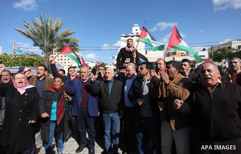Palestinian members of National and Islamic forces hold banners and Palestine flags during a protest to show solidarity with the martyrs in the West Bank, in Gaza City on December 13, 2018. Israeli forces also killed two...