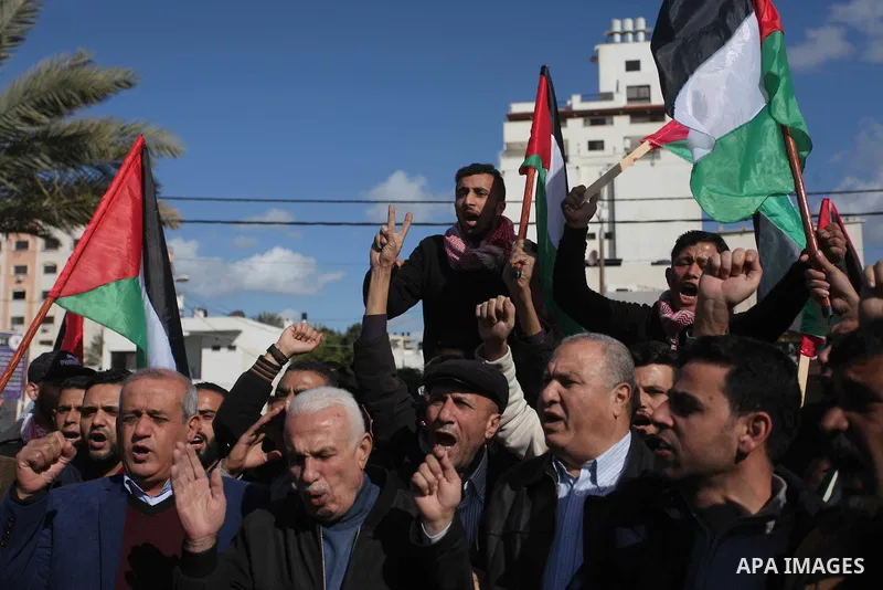Palestinian members of National and Islamic forces hold banners and Palestine flags during a protest to show solidarity with the martyrs in the West Bank, in Gaza City on December 13, 2018. Israeli forces also killed two...