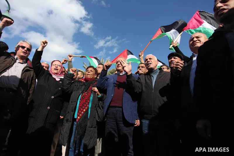 Palestinian members of National and Islamic forces hold banners and Palestine flags during a protest to show solidarity with the martyrs in the West Bank, in Gaza City on December 13, 2018. Israeli forces also killed two...