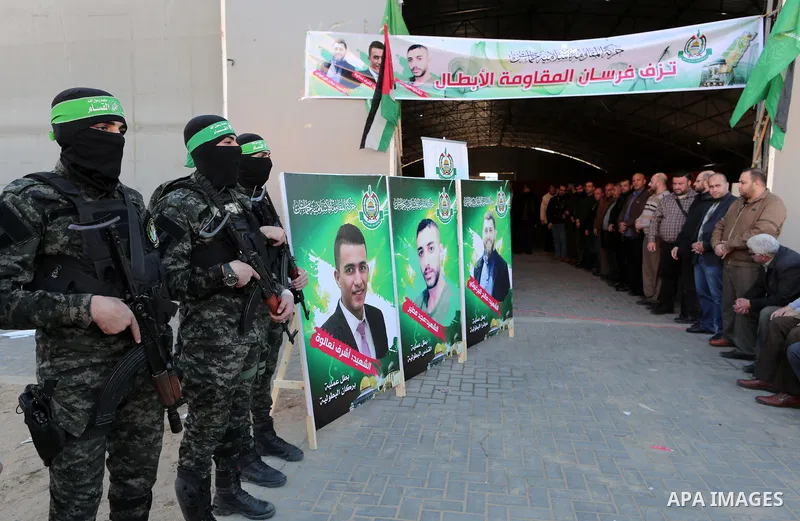 Palestinian militants of the Islamist movement Hamas' military wing Al-Qassam Brigades stand guard during a deliver consolations of three martyrs in the West Bank, in Gaza City on December 13, 2018. Photo by Mahmoud Nase...