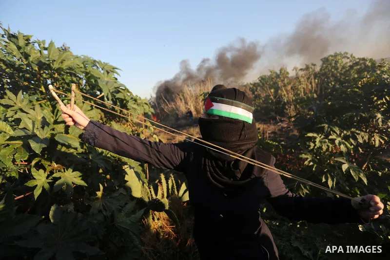 Palestinian protesters gather during clashes with Israeli troops in tents protest where Palestinians demand the right to return to their homeland at the Israel-Gaza border, in Khan Younis in the southern Gaza Strip on De...
