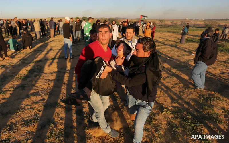Palestinian protesters gather during clashes with Israeli troops in tents protest where Palestinians demand the right to return to their homeland at the Israel-Gaza border, in Khan Younis in the southern Gaza Strip on De...