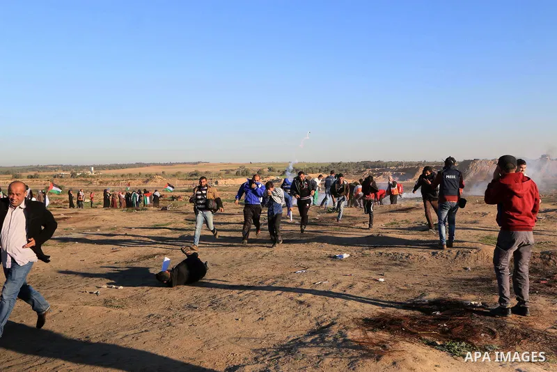 Palestinian protesters gather during clashes with Israeli troops in tents protest where Palestinians demand the right to return to their homeland at the Israel-Gaza border, in al-Bureij in the center of Gaza Strip on Dec...